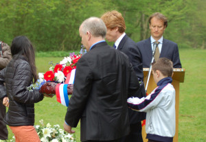 John Wilcock, U.S. Consul General laying wreath with local elementary school students.