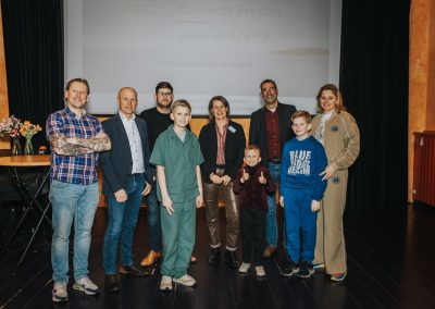 Gedeputeerde Sijbe Knol (achter), wethouders Jan van Zanden (De Fryske Marren) en Henk de Boer (Súdwest-Fryslân), directeur Iris Nutma en de hoofdrolspelers van het gezin Kloetstra.