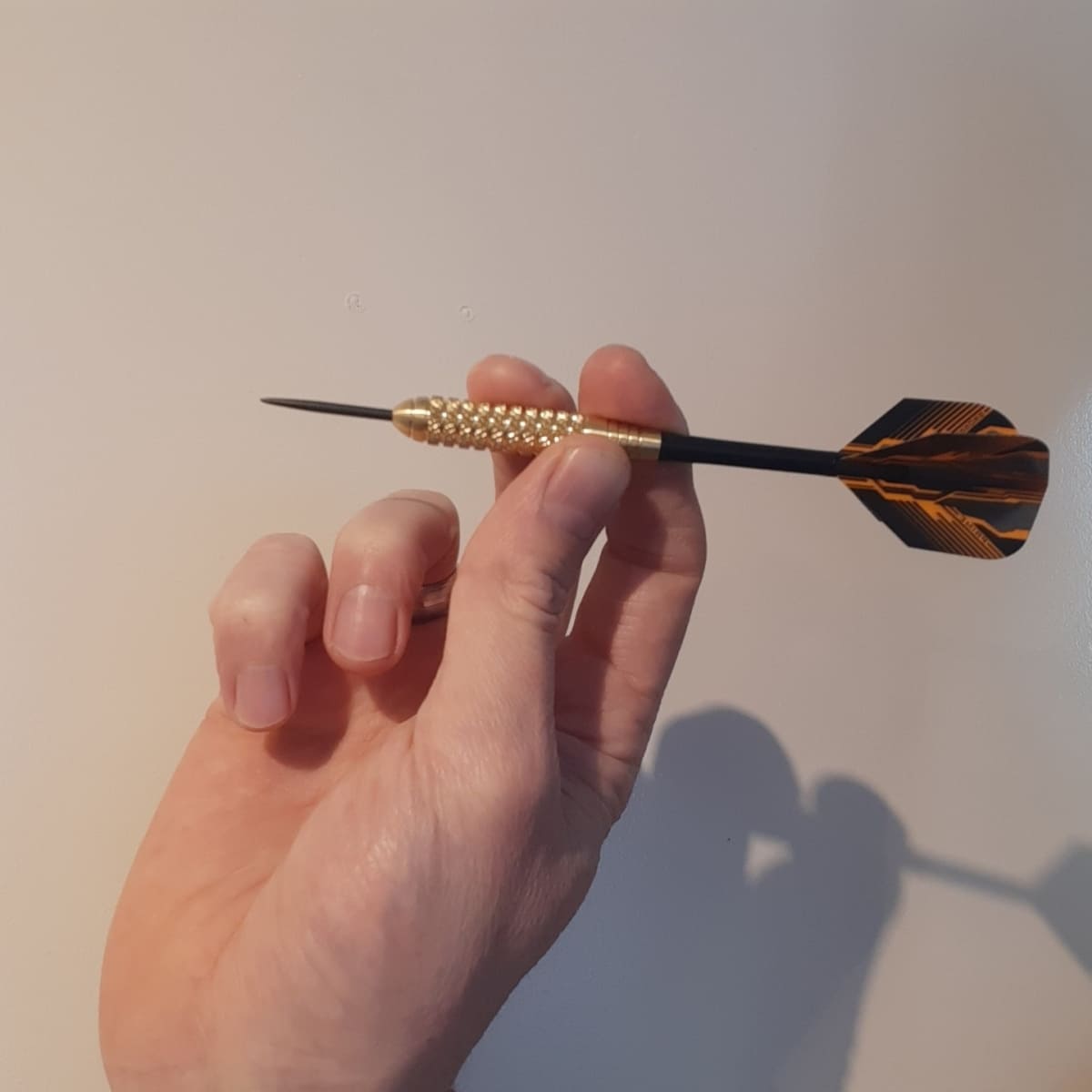 Juiste manier om een brass dartpijl vast te houden voor een stabiele worp en techniek.